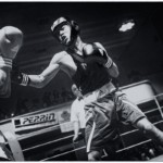 Photographie en noir et blanc d'un échange lors d'un meeting de boxe