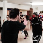 Groupe de membres du club en échauffement collectif pendant un cours de boxe